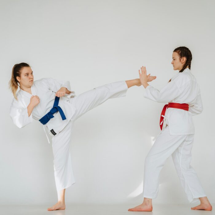 Two athletes training in white martial arts uniforms